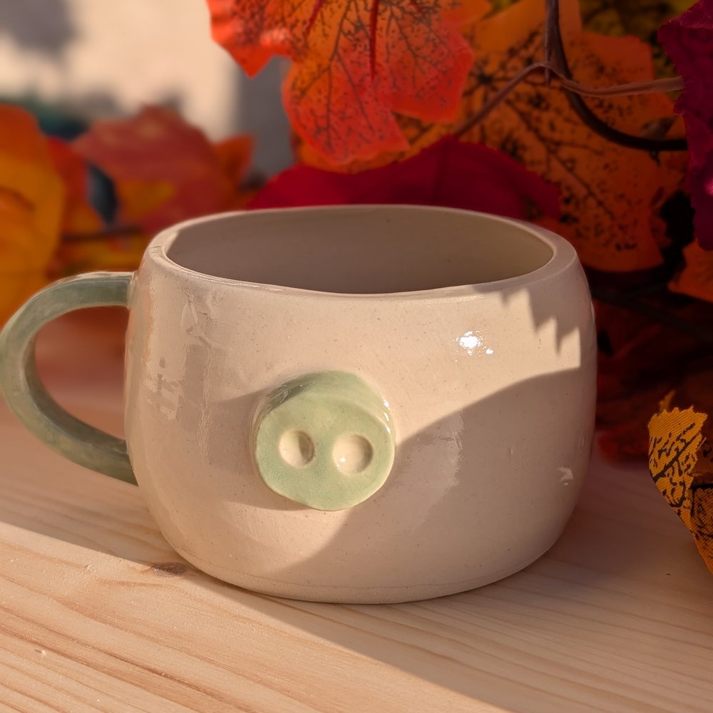 Handled mug with a pale green button snout and matching handle
